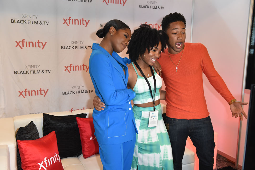An attendee meets Jacob Latimore and Ryan Destiny at the Comcast Xfinity Exhibit
