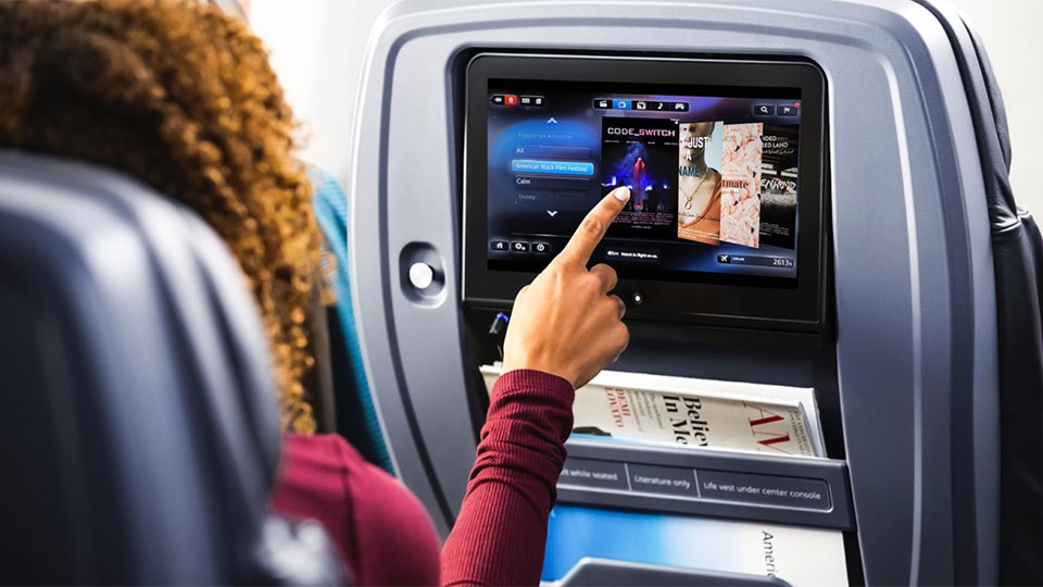 Woman scrolling through movie options on airplane